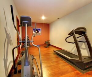 A home gym with cross-trainer and treadmill.