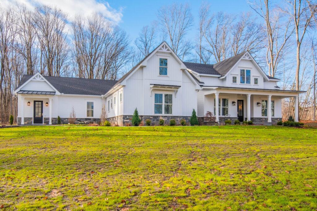 a large white house in the middle of a field