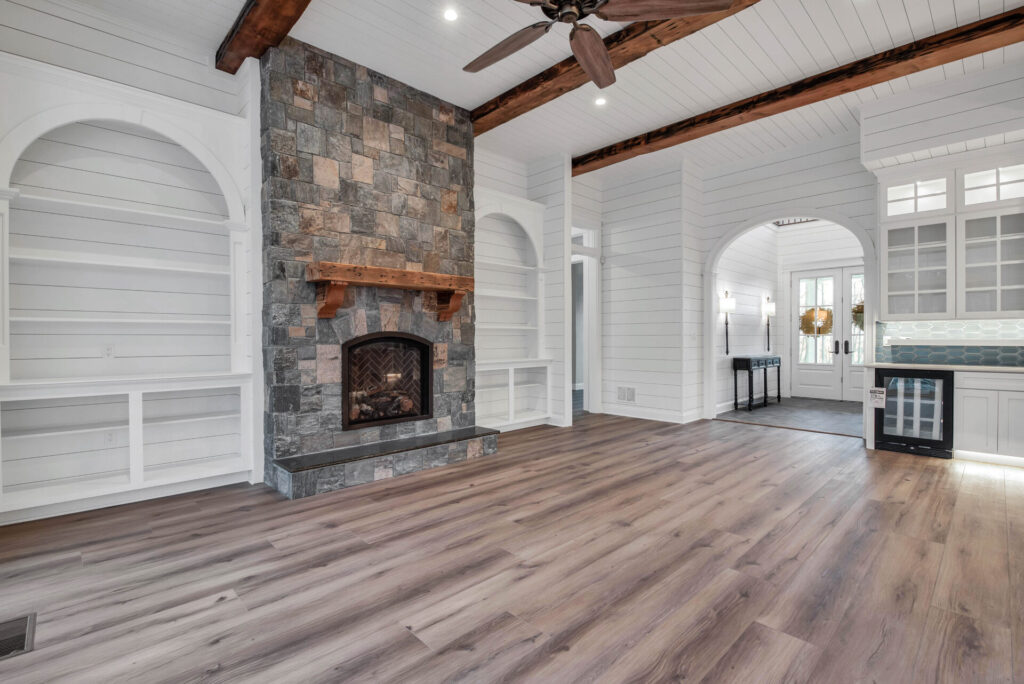 a large living room with a fireplace and white walls