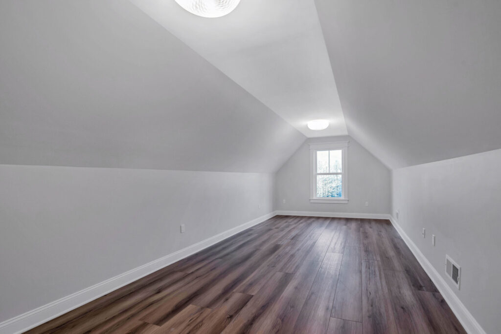 an empty room with white walls and wood floors