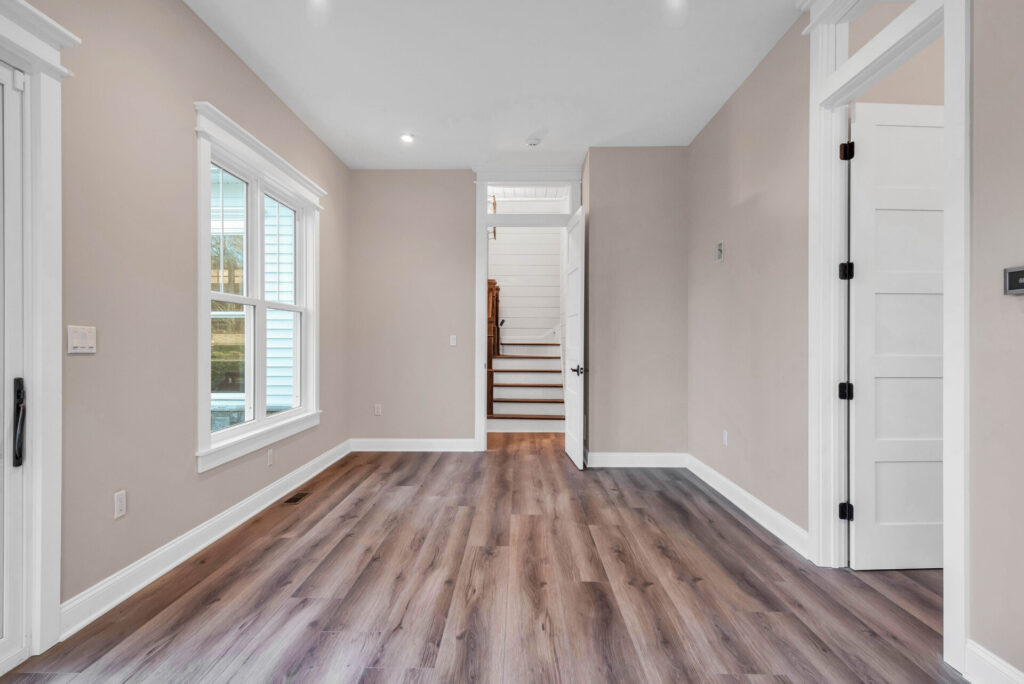 a large empty room with wood floors and white trim