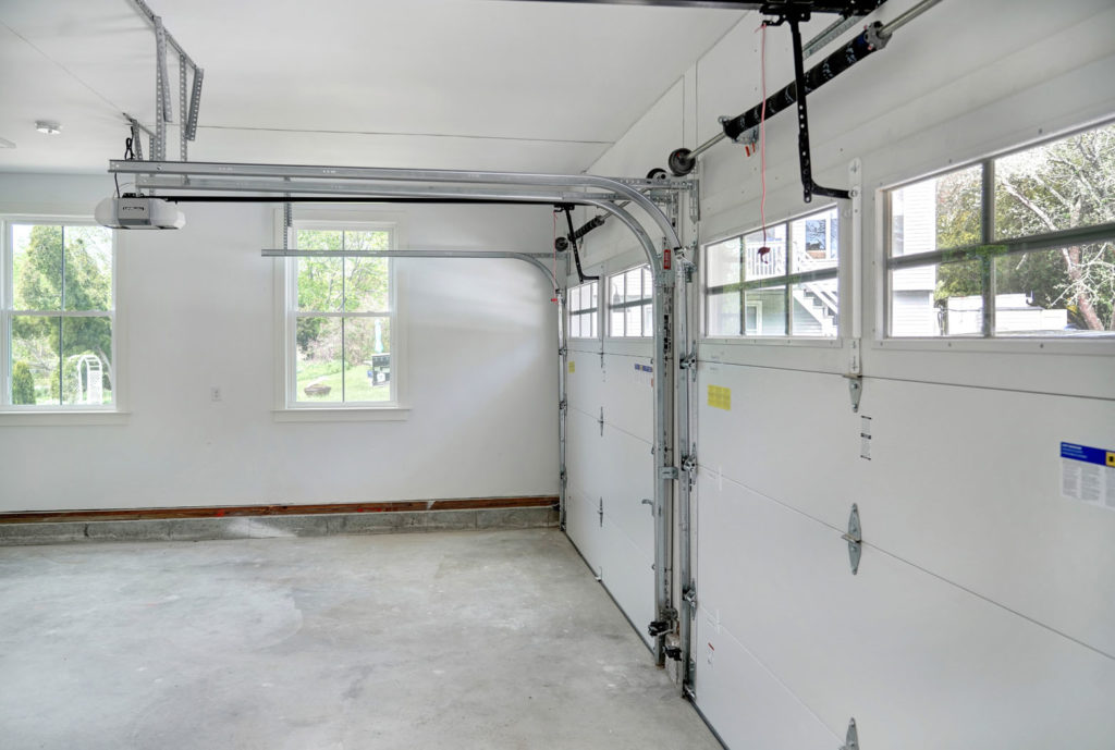 Inside of an empty garage with two newly installed garage doors