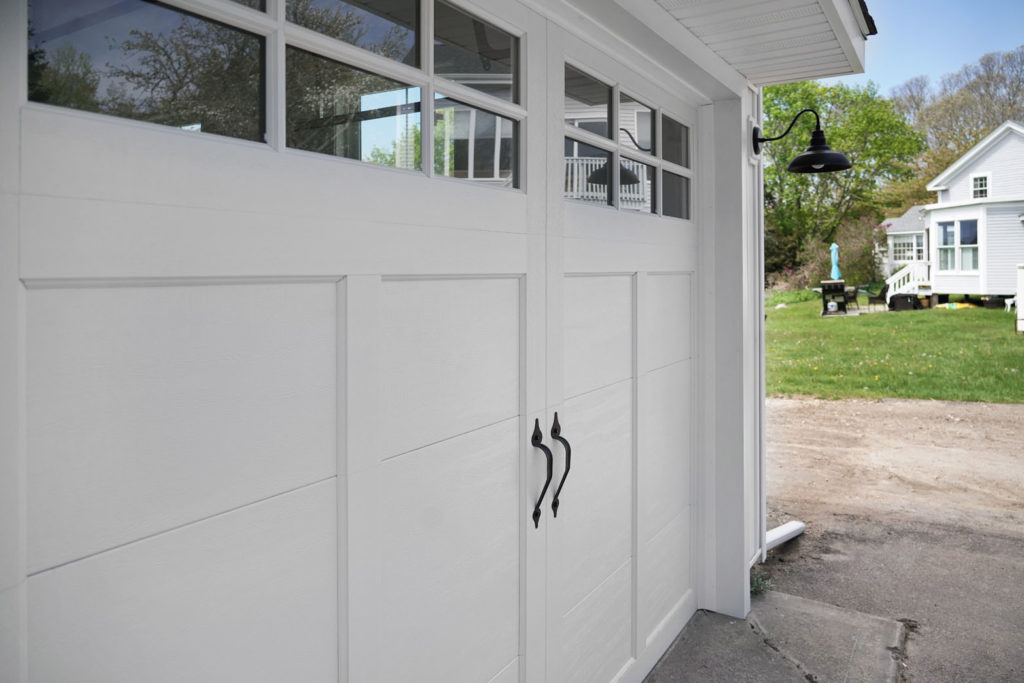 Outside of a garage with new barn-style white garage doors
