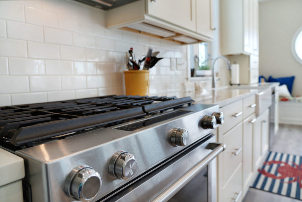 Stainless steel gas stove / gas range in white kitchen with subway tile backsplash