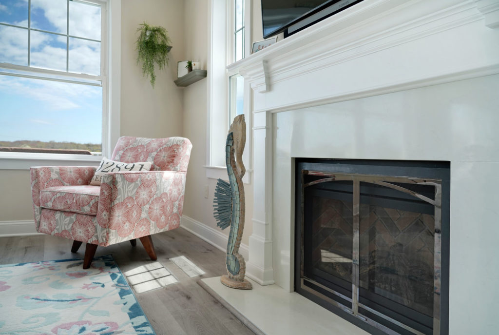 Home with fireplace with white brick and white trim and new window with seating