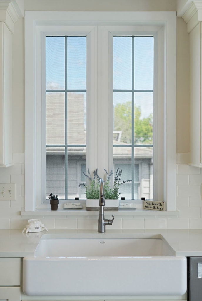 New white kitchen window with white trim and farmhouse sink