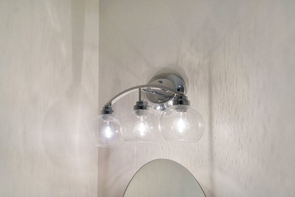 New silver / chrome bathroom light fixture over mirror