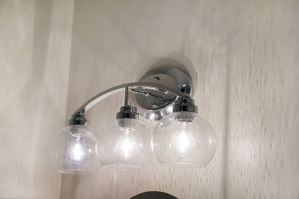 Silver / chrome light fixture in bathroom with glass light covers