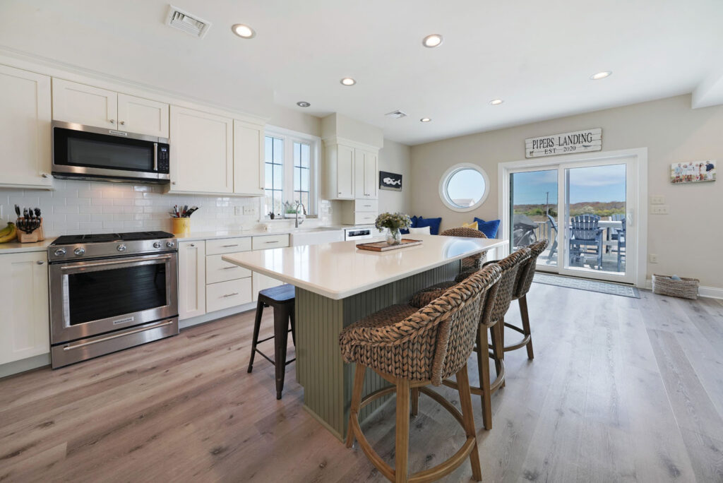 Kitchen with new white cabinets and island with solid countertop and stainless appliances