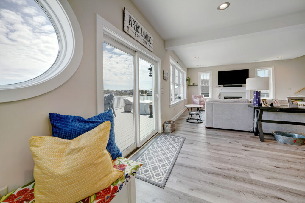 a living room with gray wood flooring and a glass sliding door