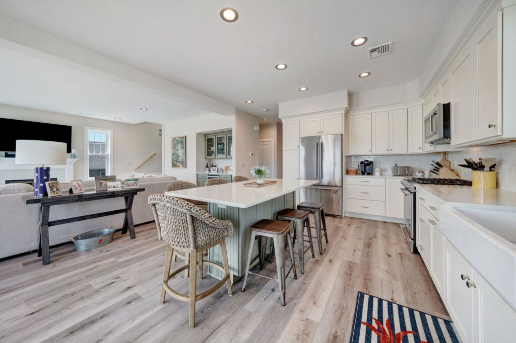 a kitchen with white cabinets and wooden floors