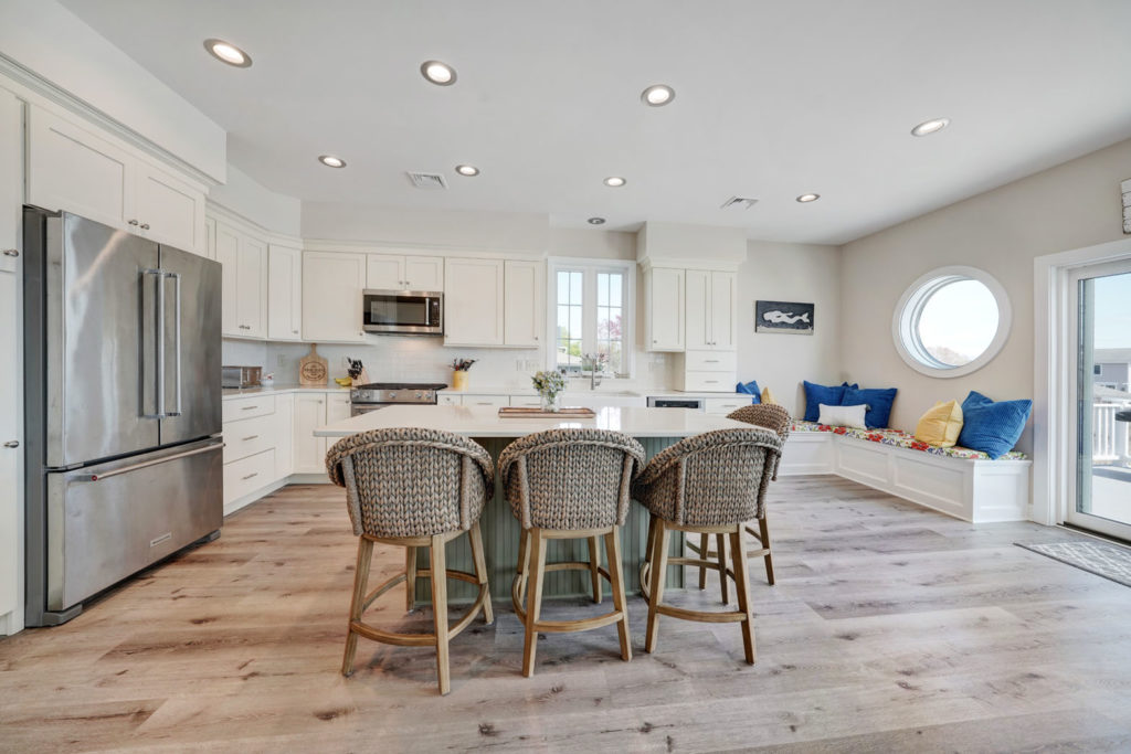 a kitchen with white cabinets and an island with barstools