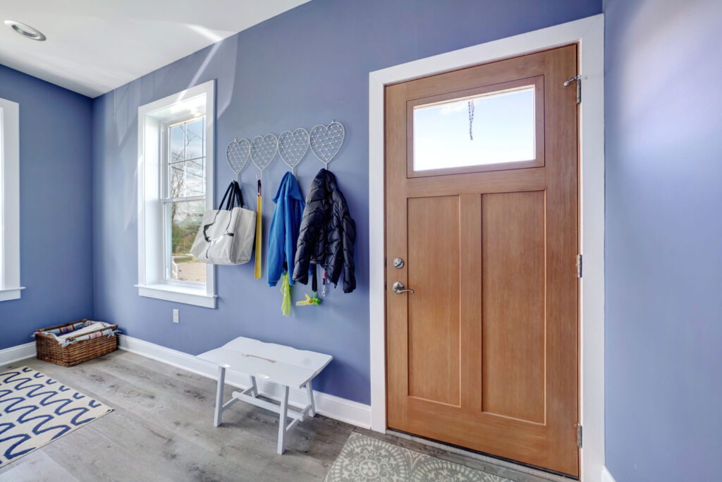 an entry way with a bench and hooks to hang coats