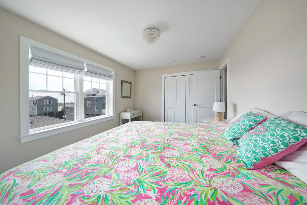 A bedroom with a large bed and a window - addition built by Fidero & Sons in Meriden, CT.