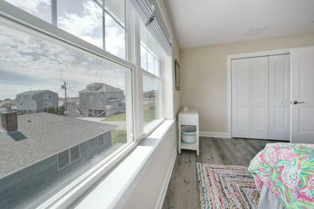 A bedroom with a bed and a large window built by Fidero & Sons in Meriden, CT.