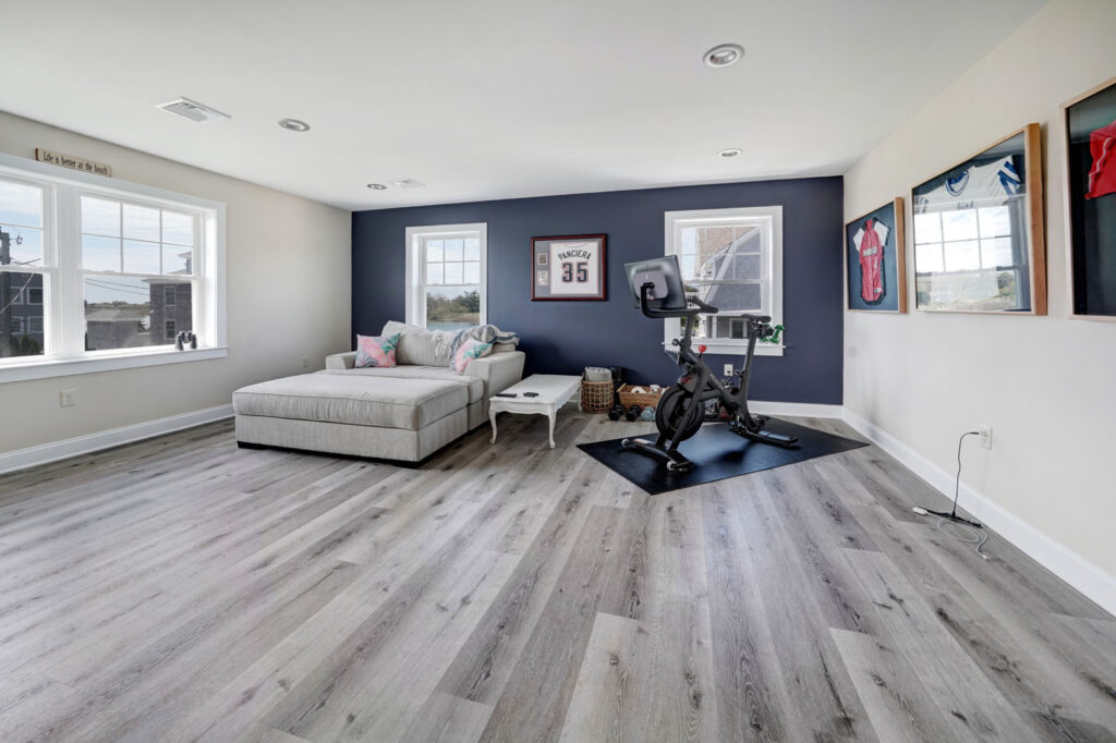 A living room & gym addition with hardwood floors and blue walls built by Fidero & Sons in Meriden, CT.