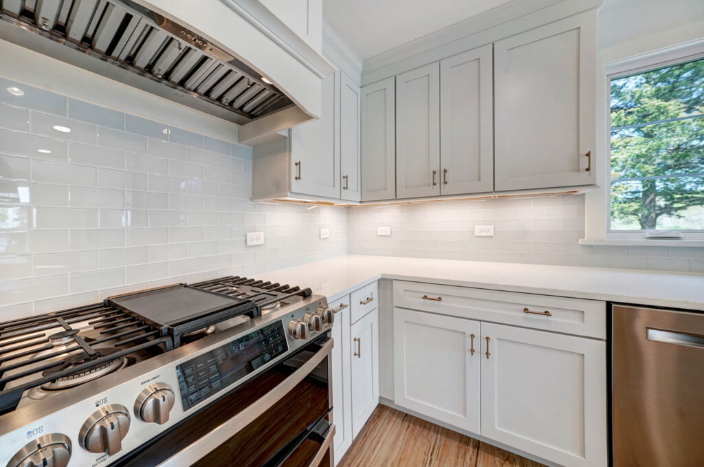 Kitchen with white counters, grey cabinets, and stainless steel appliances.