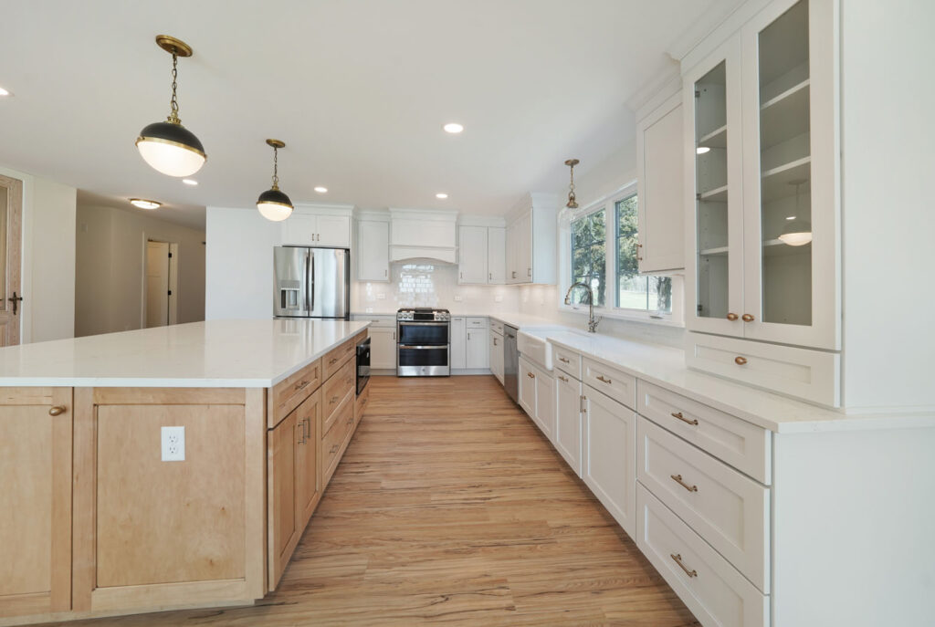 An open concept residential kitchen with large kitchen island & white cabinets.