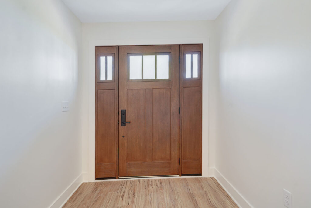 A residential, wood front door with windows.