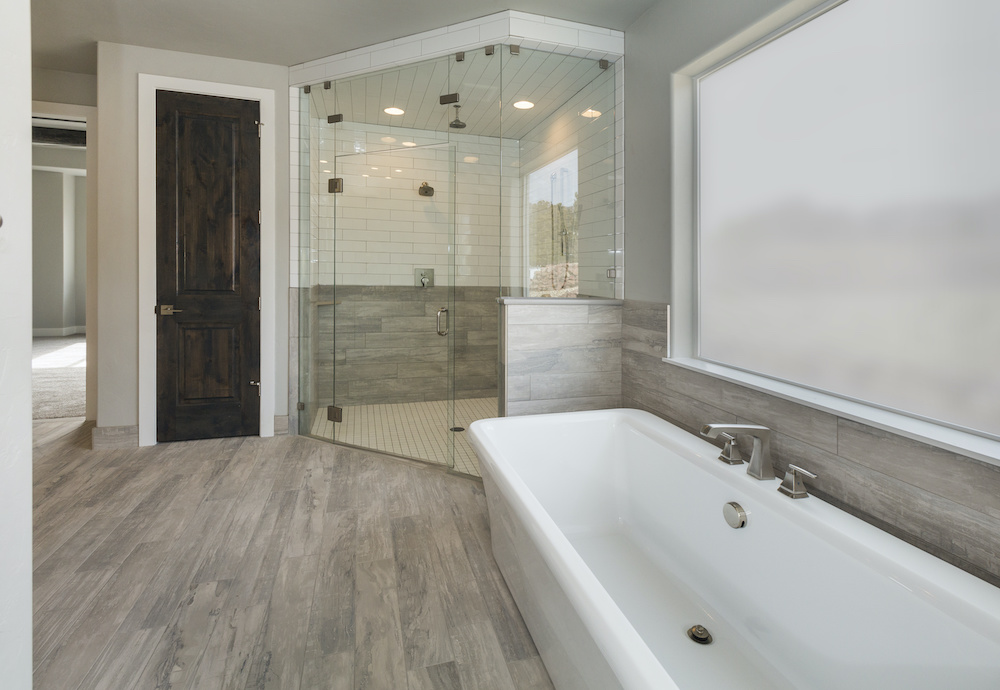 Luxury Master Bathroom recently remodeled to include a glass standing shower, tub, and new flooring.