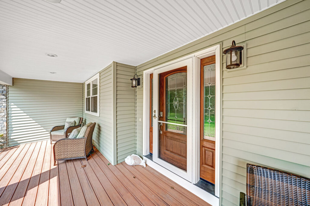 Front porch of a house and a front door with window.