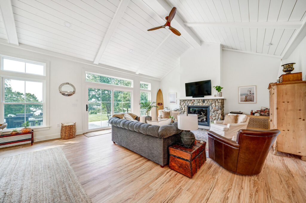 Grey sofa in an a-frame home with fireplace in background.
