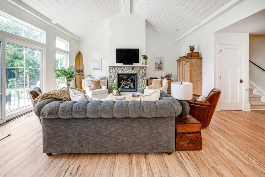 Grey sofa in an a-frame home with fireplace in background.