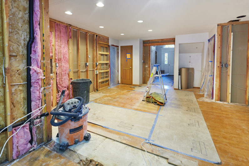 Basement room during construction; exposed insulation on walls and subfloors exposed on the floor.