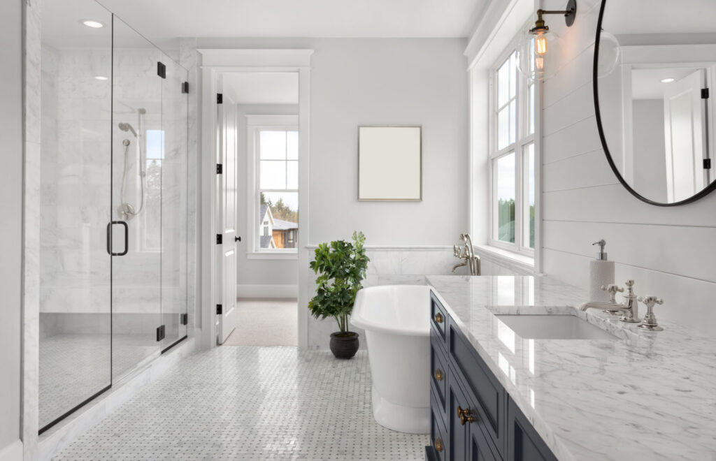 Bathroom with mosaic tile floor, frameless shower, and soaking tub.
