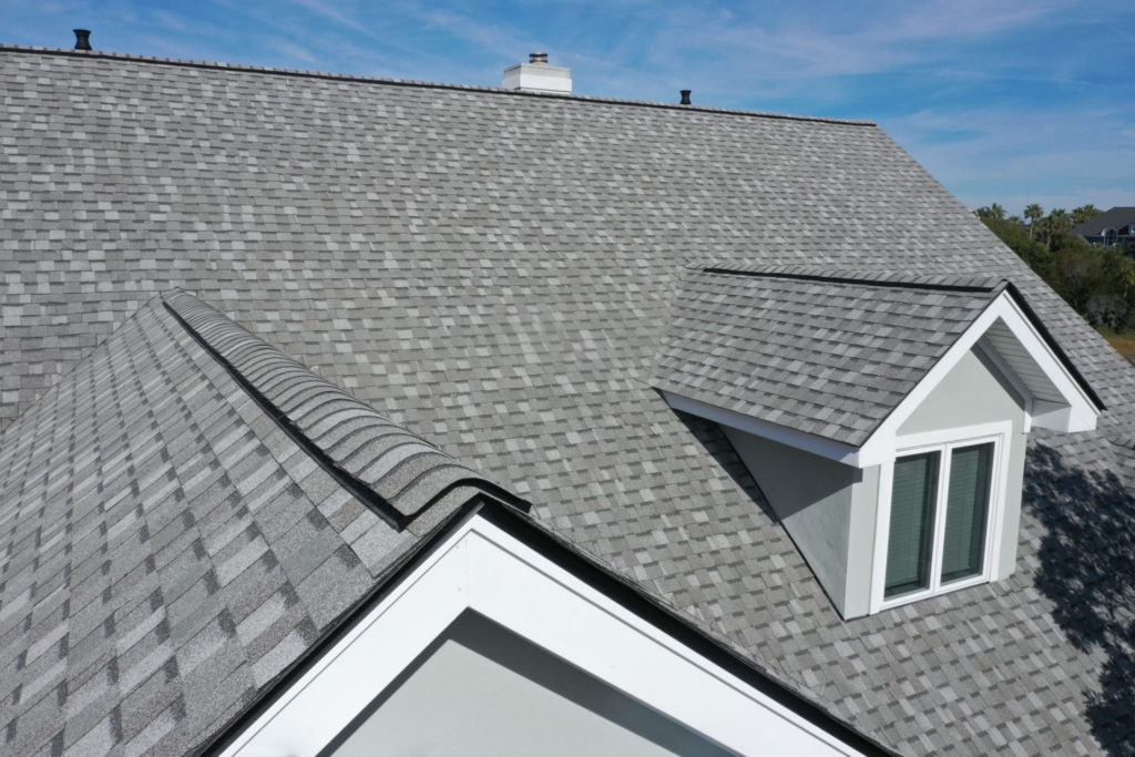 Aerial view of home's roof with newly installed gray shingles.
