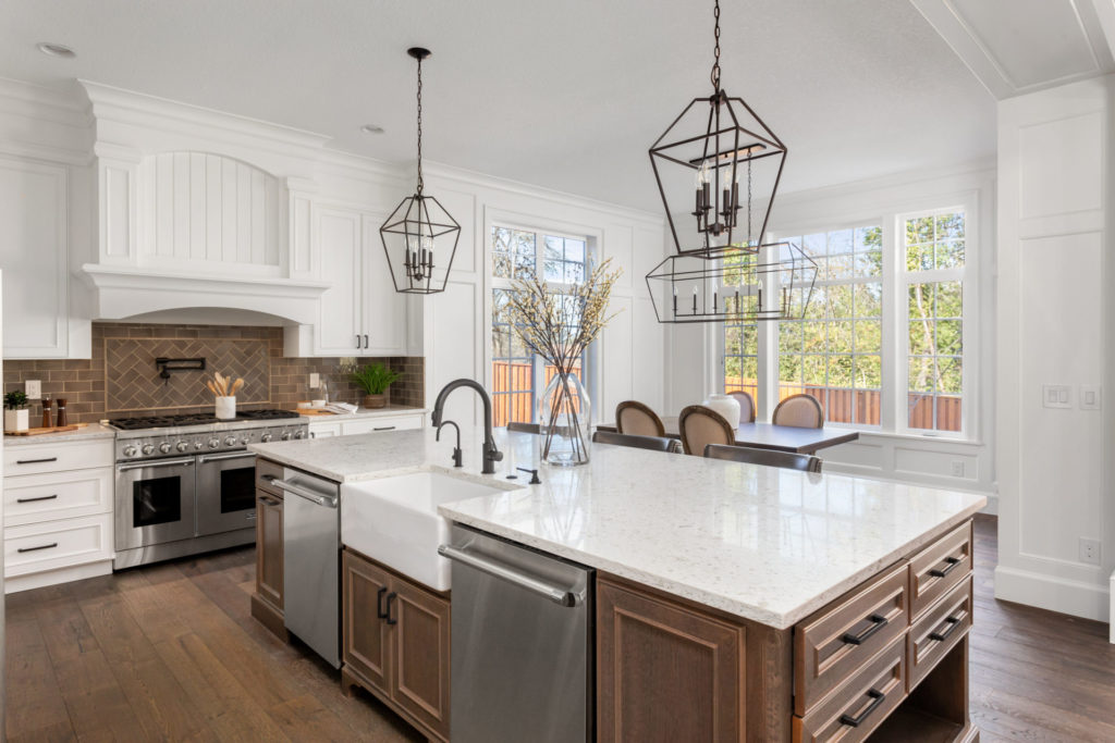 Modern kitchen with granite island, brown distressed cabinets, and brick backsplash.
