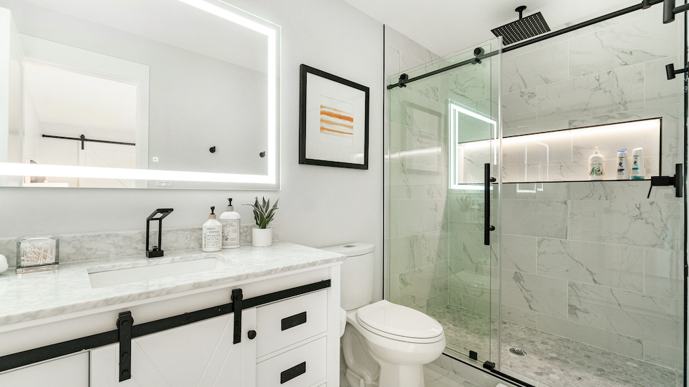 Modern white bathroom with vanity, toilet, and shower