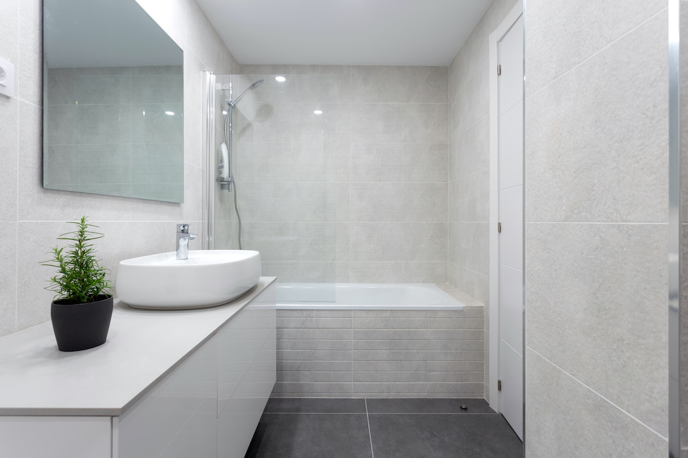 White bathroom with vanity and shower/bath combination