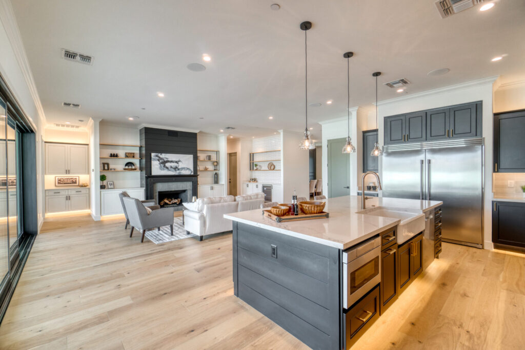 a kitchen with a center island next to a living room